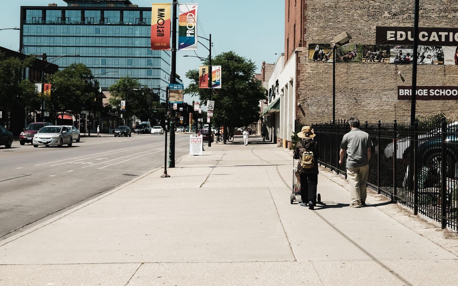 A sunny Chicago sidewalk with people out on the block