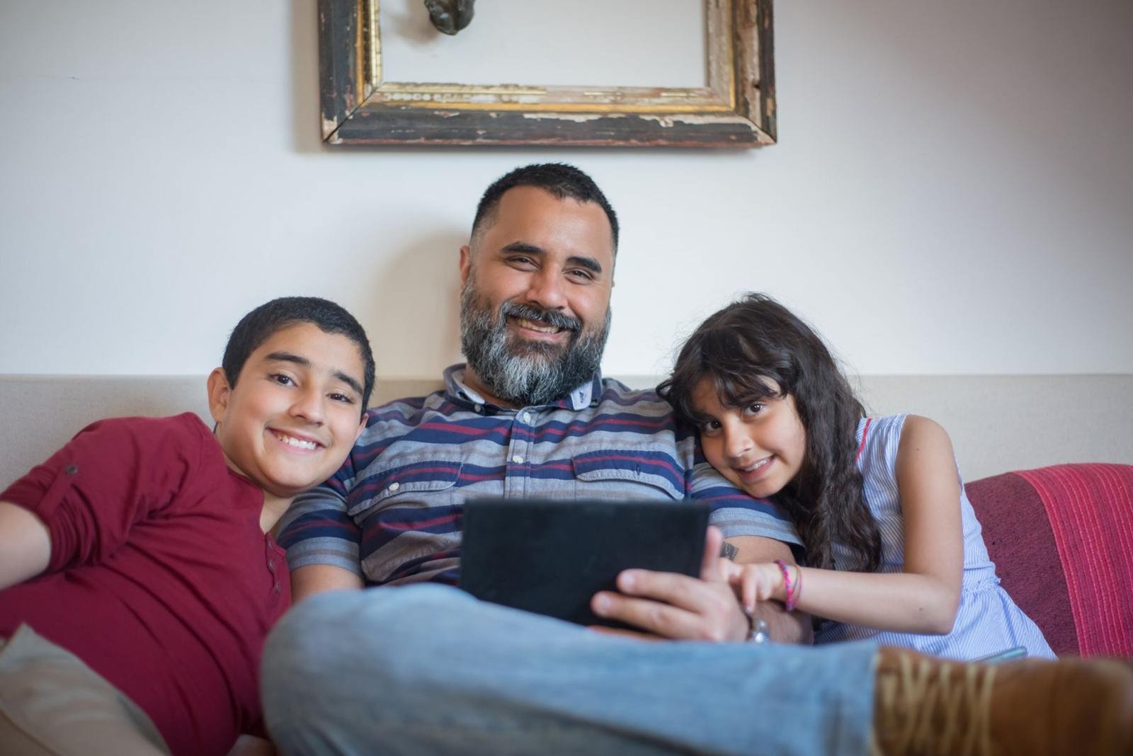A father and two children relaxing together at home
